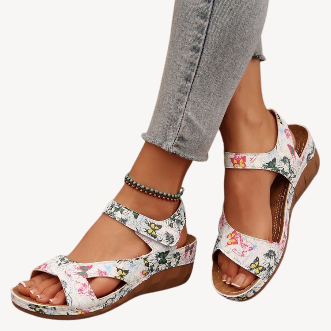 Black women's leather orthopedic sandals with adjustable Velcro straps, low wedge heel, and flexible sole for comfort.