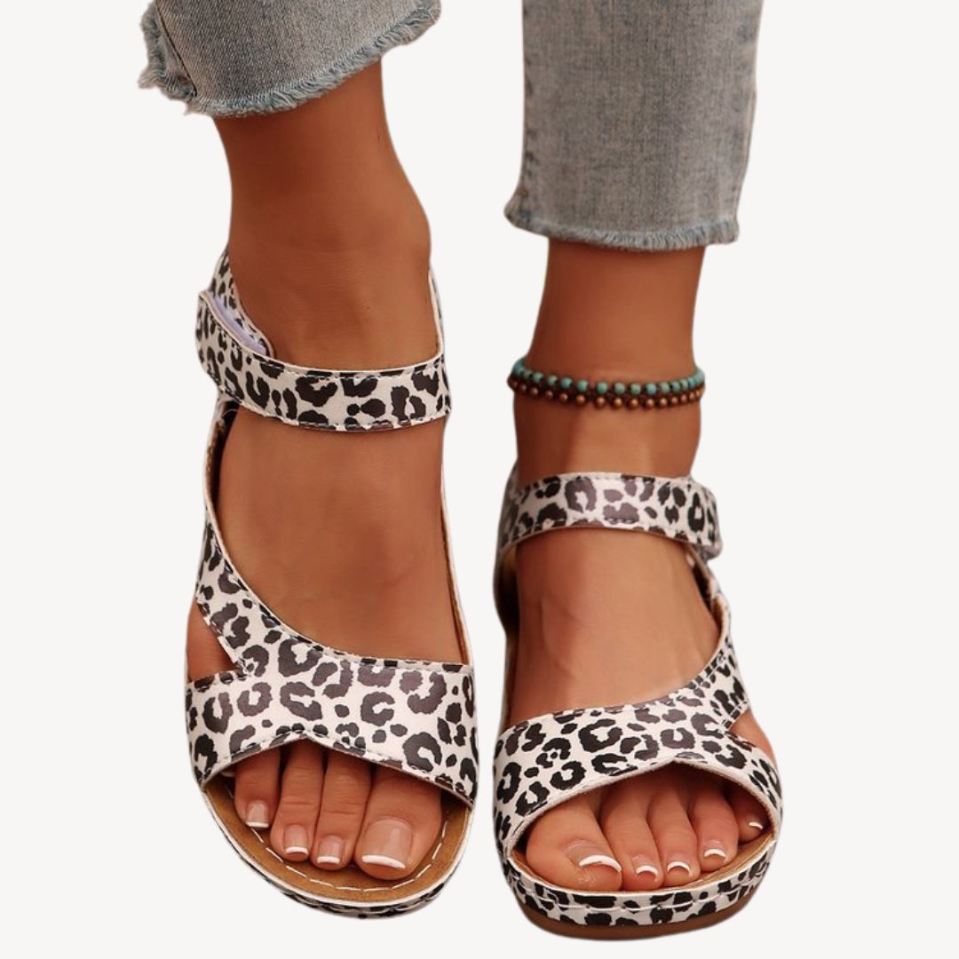 Black women's leather orthopedic sandals with adjustable Velcro straps, low wedge heel, and flexible sole for comfort.