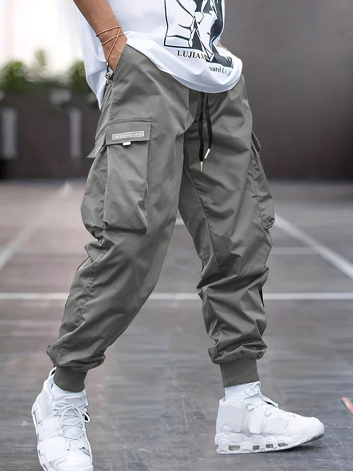"Durable men's black cargo pants front view with multiple pockets, sleek modern fit, versatile style for urban adventures."