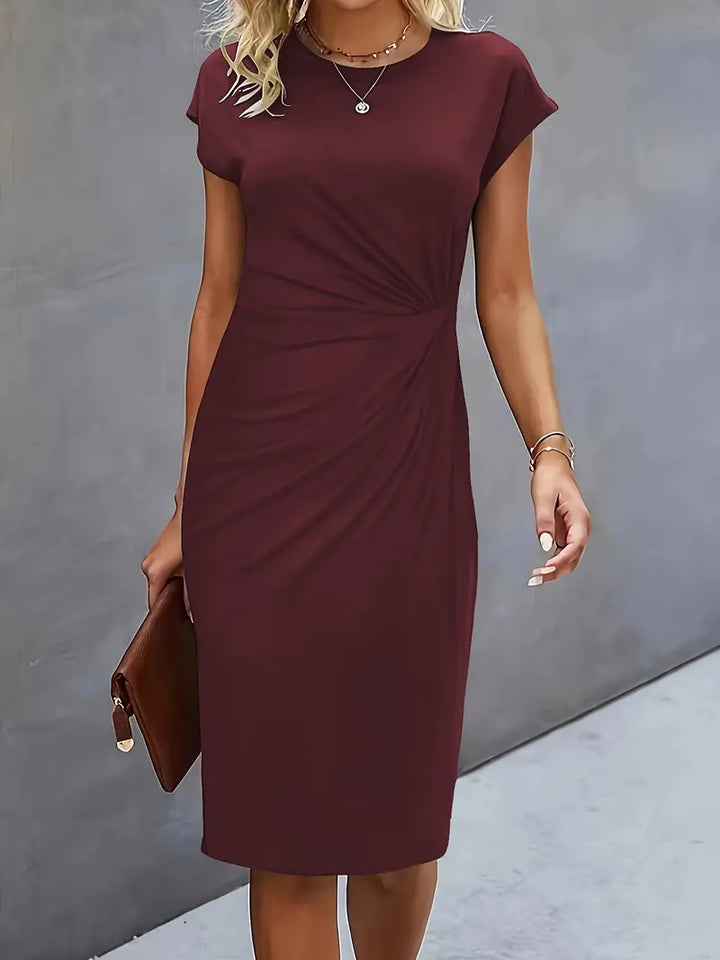 Elegant women's knee-length sheath dress with ruched waist, shown in dark green. Perfect for day-to-night wear.
