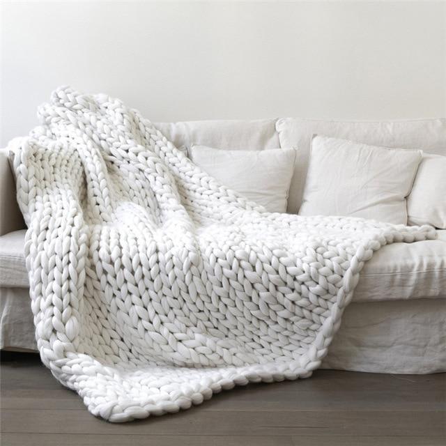 "Handmade chunky knit blanket, super soft texture, vibrant colors draped on furniture, decorative and cozy home accent."