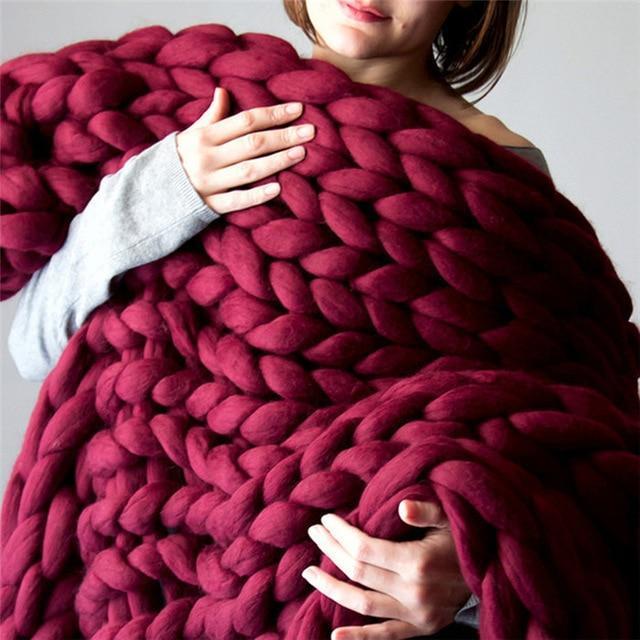 "Handmade chunky knit blanket, super soft texture, vibrant colors draped on furniture, decorative and cozy home accent."