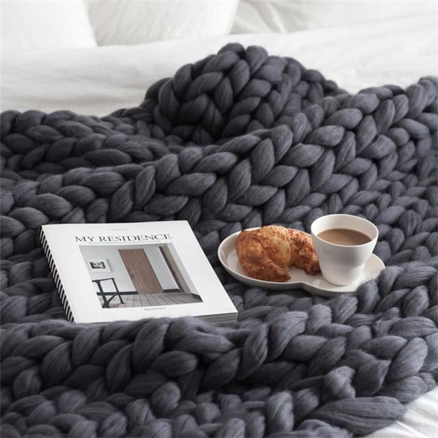"Handmade chunky knit blanket, super soft texture, vibrant colors draped on furniture, decorative and cozy home accent."