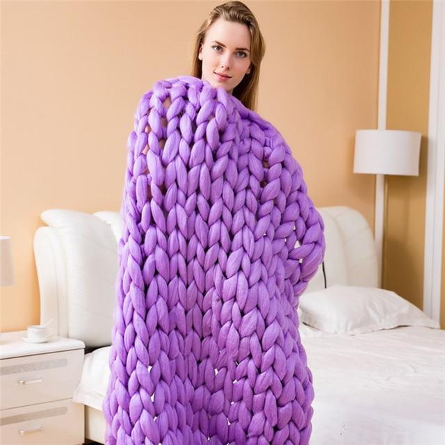 "Handmade chunky knit blanket, super soft texture, vibrant colors draped on furniture, decorative and cozy home accent."