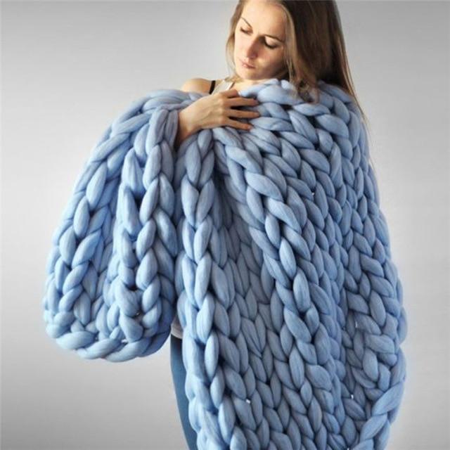 "Handmade chunky knit blanket, super soft texture, vibrant colors draped on furniture, decorative and cozy home accent."
