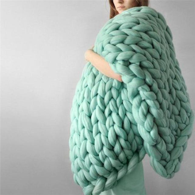 "Handmade chunky knit blanket, super soft texture, vibrant colors draped on furniture, decorative and cozy home accent."
