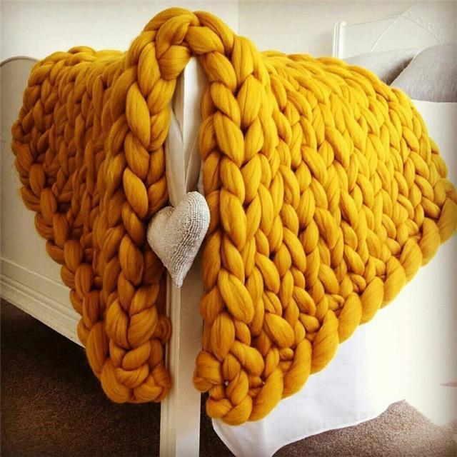 "Handmade chunky knit blanket, super soft texture, vibrant colors draped on furniture, decorative and cozy home accent."