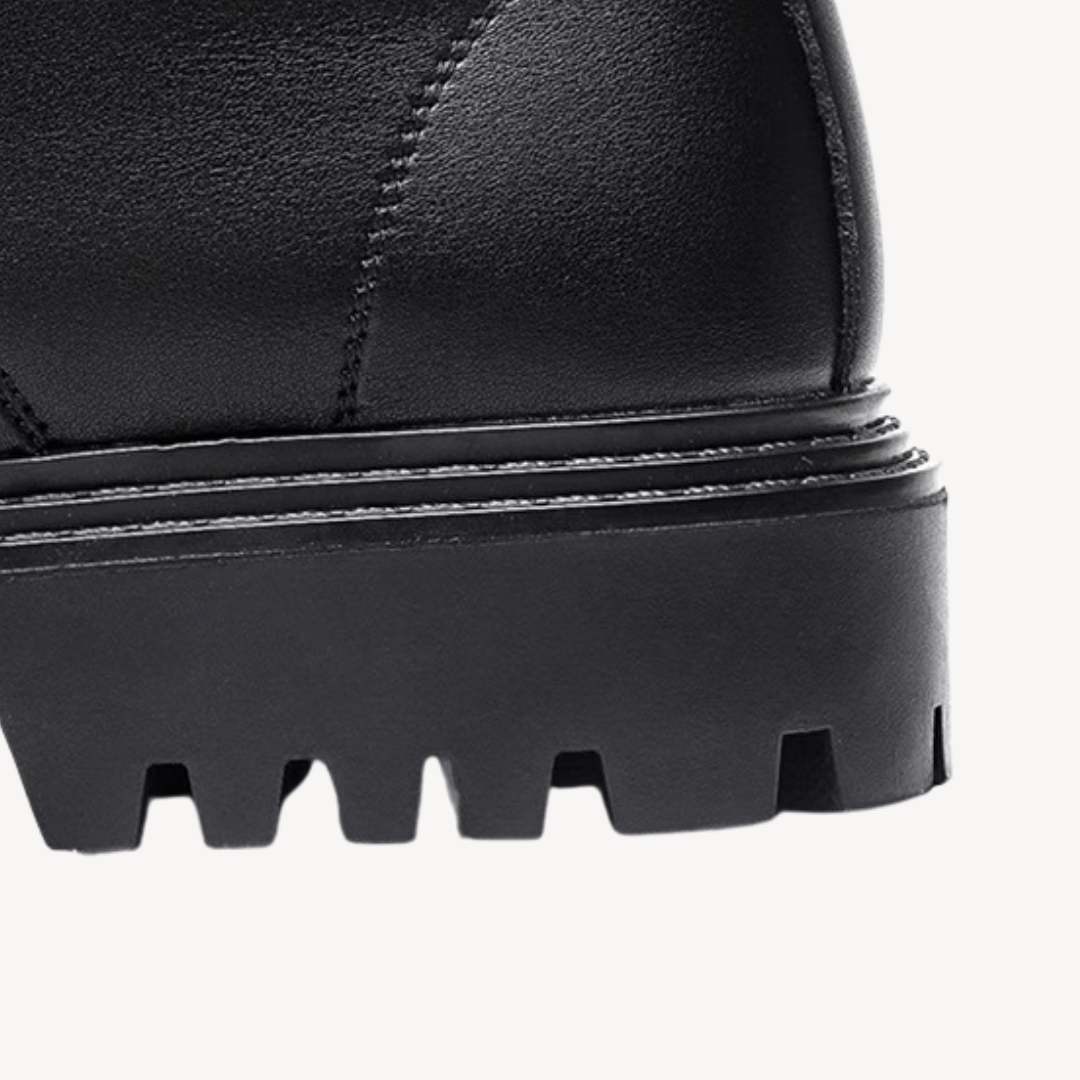 "Men's black leather combat boots with chunky sole, front view, showcasing rugged durability and modern style in premium mate