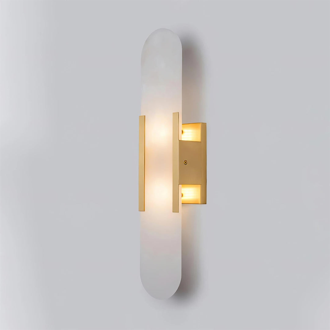 "Modern elongated alabaster wall lamp with metal and brass accents, emits warm glow, suitable for chic interior decor."