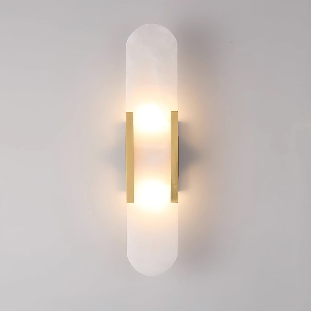 "Modern elongated alabaster wall lamp with metal and brass accents, emits warm glow, suitable for chic interior decor."