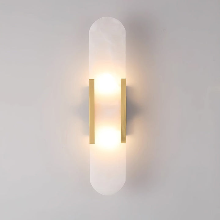 "Modern elongated alabaster wall lamp with metal and brass accents, emits warm glow, suitable for chic interior decor."