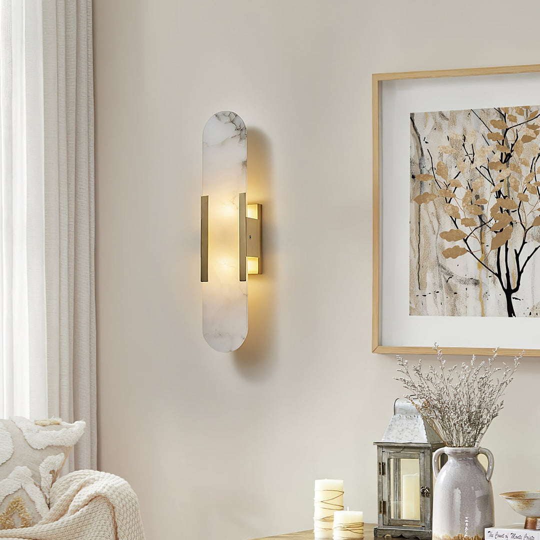 "Modern elongated alabaster wall lamp with metal and brass accents, emits warm glow, suitable for chic interior decor."