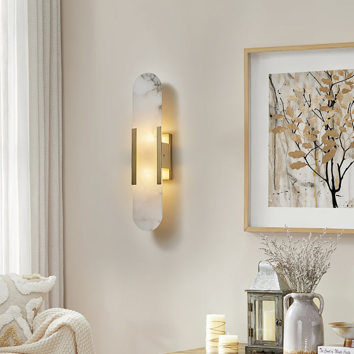 "Modern elongated alabaster wall lamp with metal and brass accents, emits warm glow, suitable for chic interior decor."