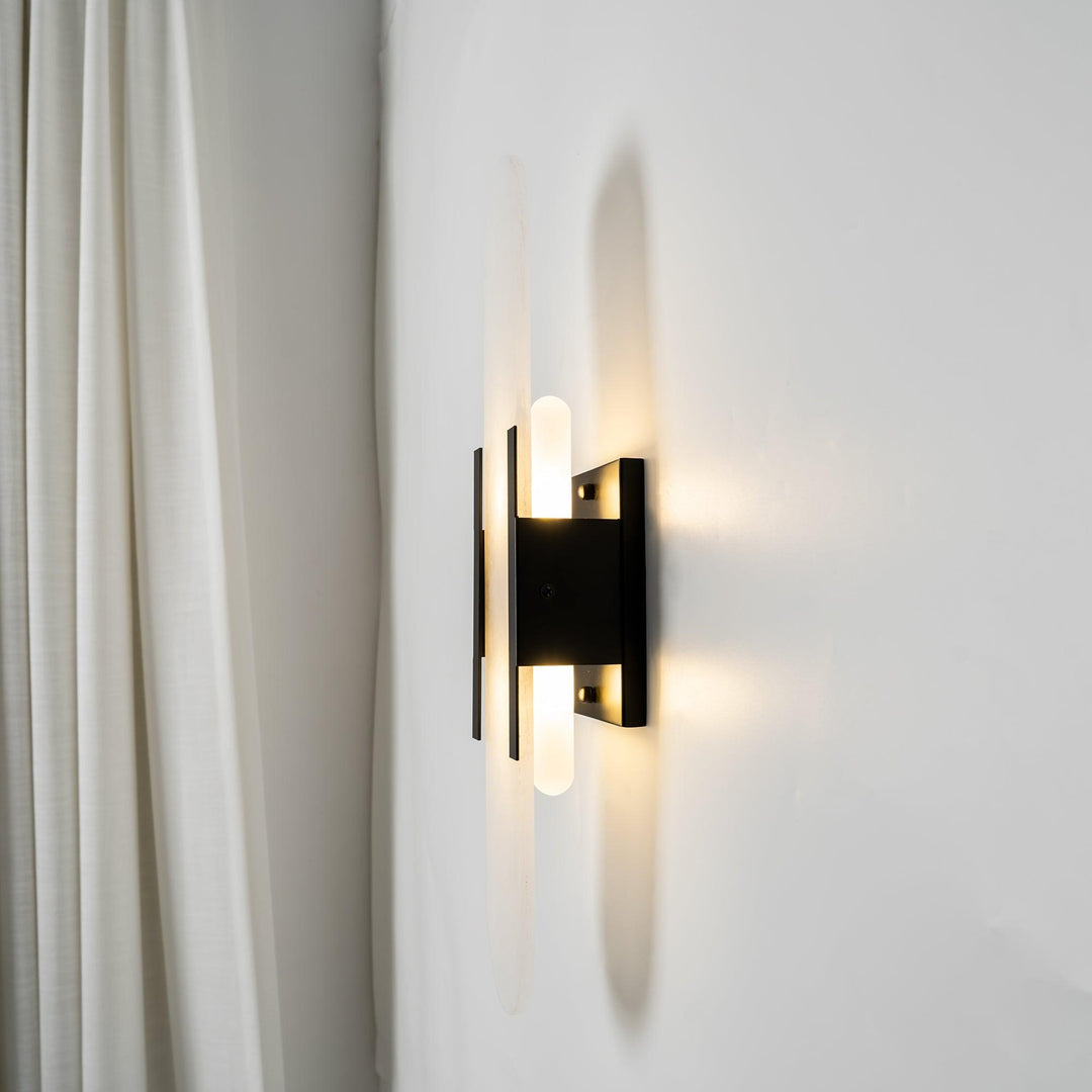 "Modern elongated alabaster wall lamp with metal and brass accents, emits warm glow, suitable for chic interior decor."