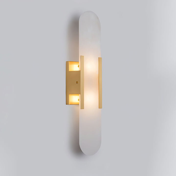 "Modern elongated alabaster wall lamp with metal and brass accents, emits warm glow, suitable for chic interior decor."