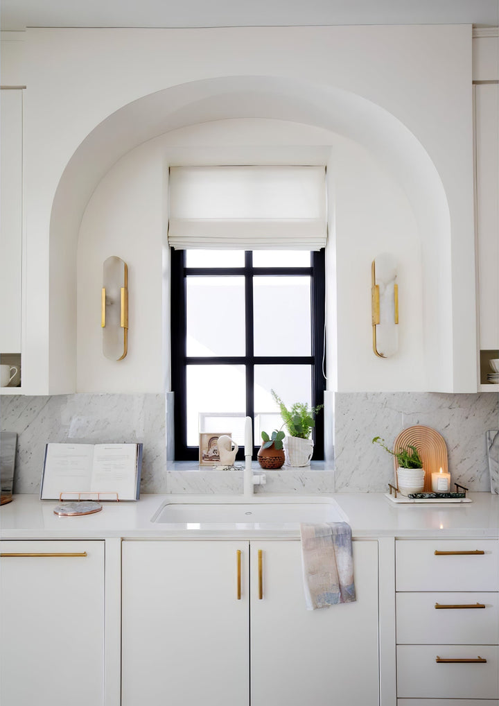 "Modern elongated alabaster wall lamp with metal and brass accents, emits warm glow, suitable for chic interior decor."