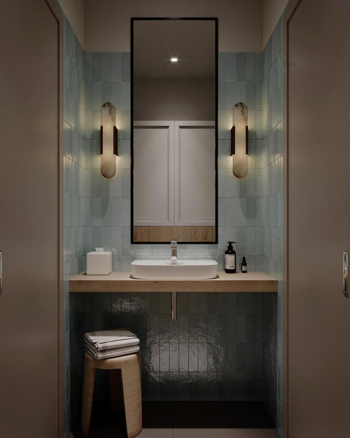 "Modern elongated alabaster wall lamp with metal and brass accents, emits warm glow, suitable for chic interior decor."