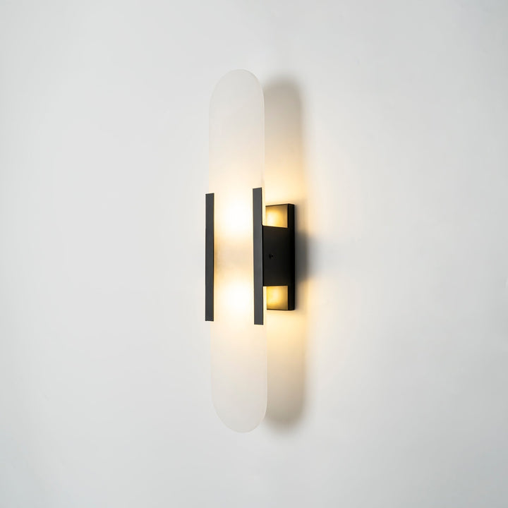 "Modern elongated alabaster wall lamp with metal and brass accents, emits warm glow, suitable for chic interior decor."