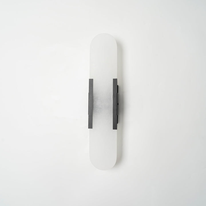 "Modern elongated alabaster wall lamp with metal and brass accents, emits warm glow, suitable for chic interior decor."