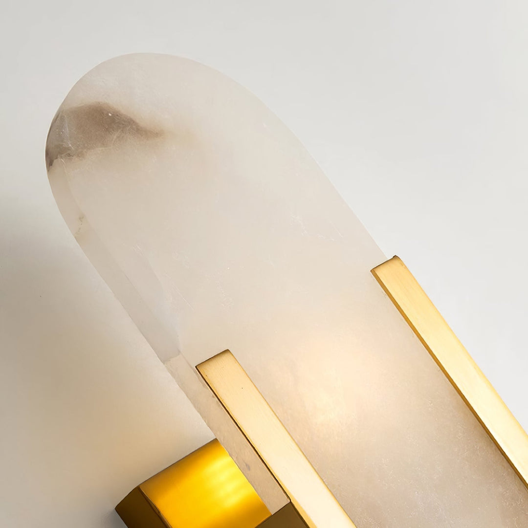 "Modern elongated alabaster wall lamp with metal and brass accents, emits warm glow, suitable for chic interior decor."