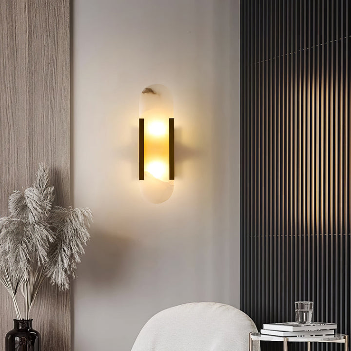 "Modern elongated alabaster wall lamp with metal and brass accents, emits warm glow, suitable for chic interior decor."