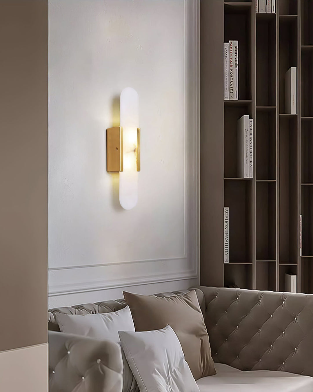 "Modern elongated alabaster wall lamp with metal and brass accents, emits warm glow, suitable for chic interior decor."