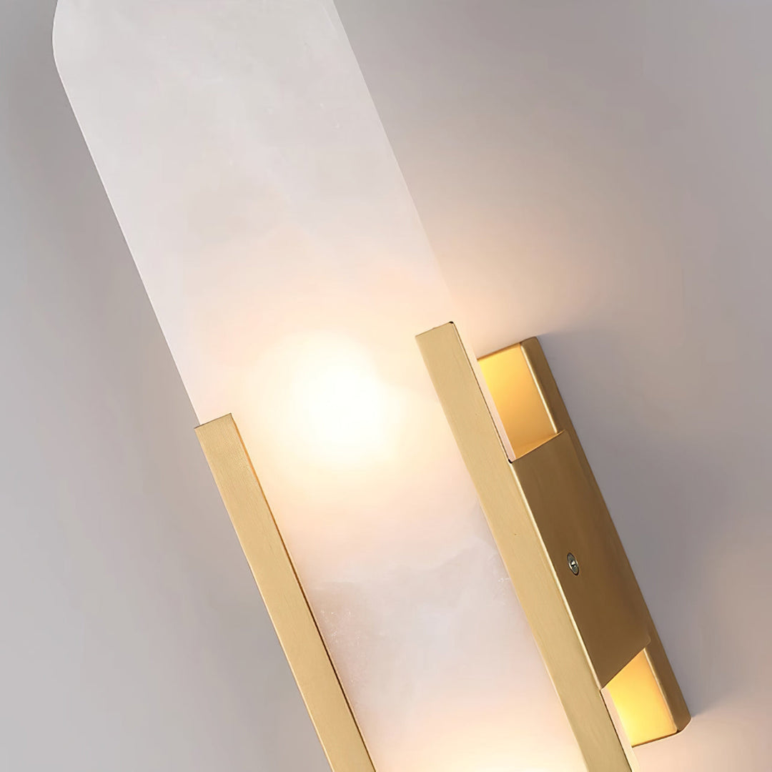 "Modern elongated alabaster wall lamp with metal and brass accents, emits warm glow, suitable for chic interior decor."