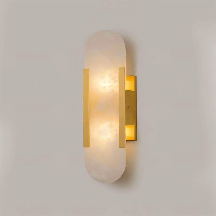 "Modern elongated alabaster wall lamp with metal and brass accents, emits warm glow, suitable for chic interior decor."