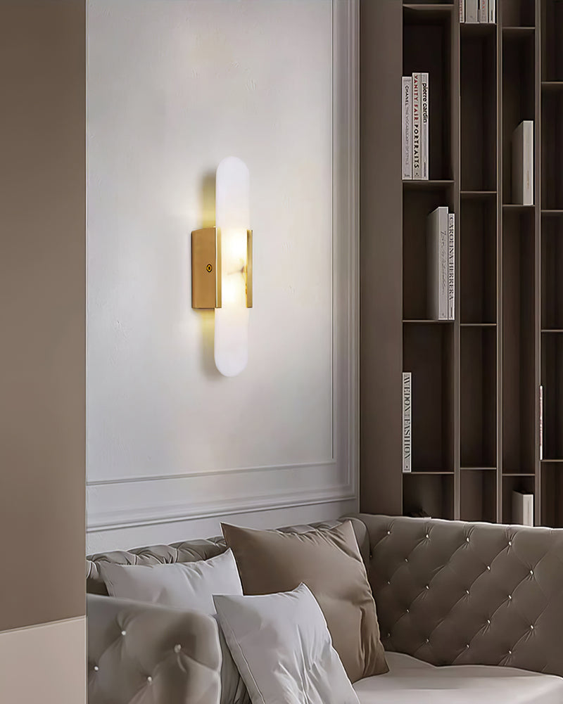 "Modern elongated alabaster wall lamp with metal and brass accents, emits warm glow, suitable for chic interior decor."