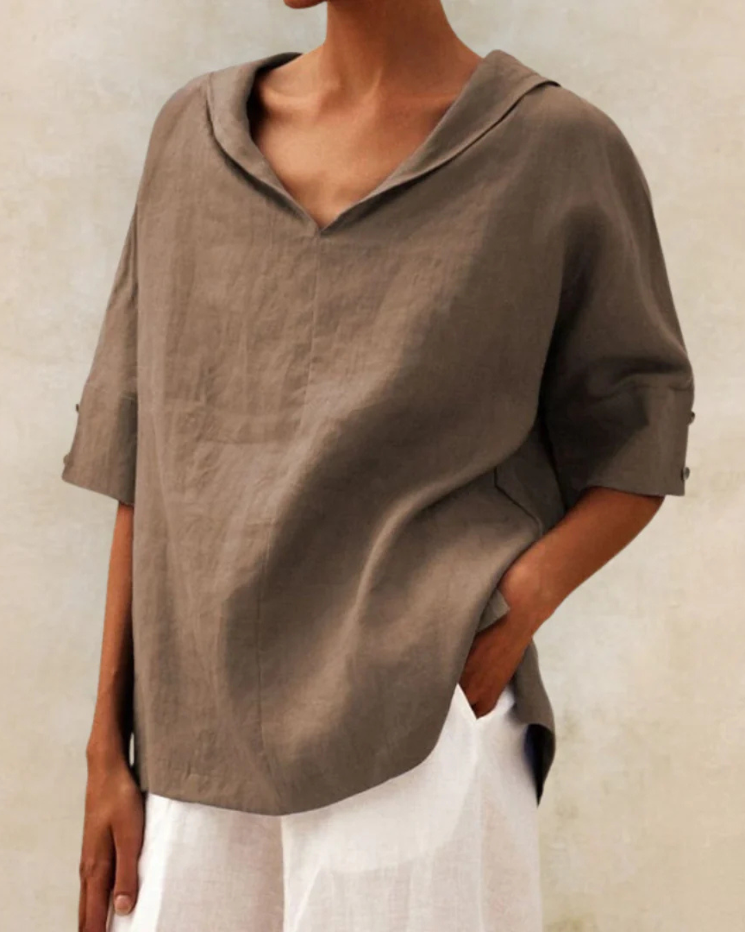 "Women's linen blouse with V-neck and half sleeves, lightweight fabric, chic design, ideal for spring and summer wear."