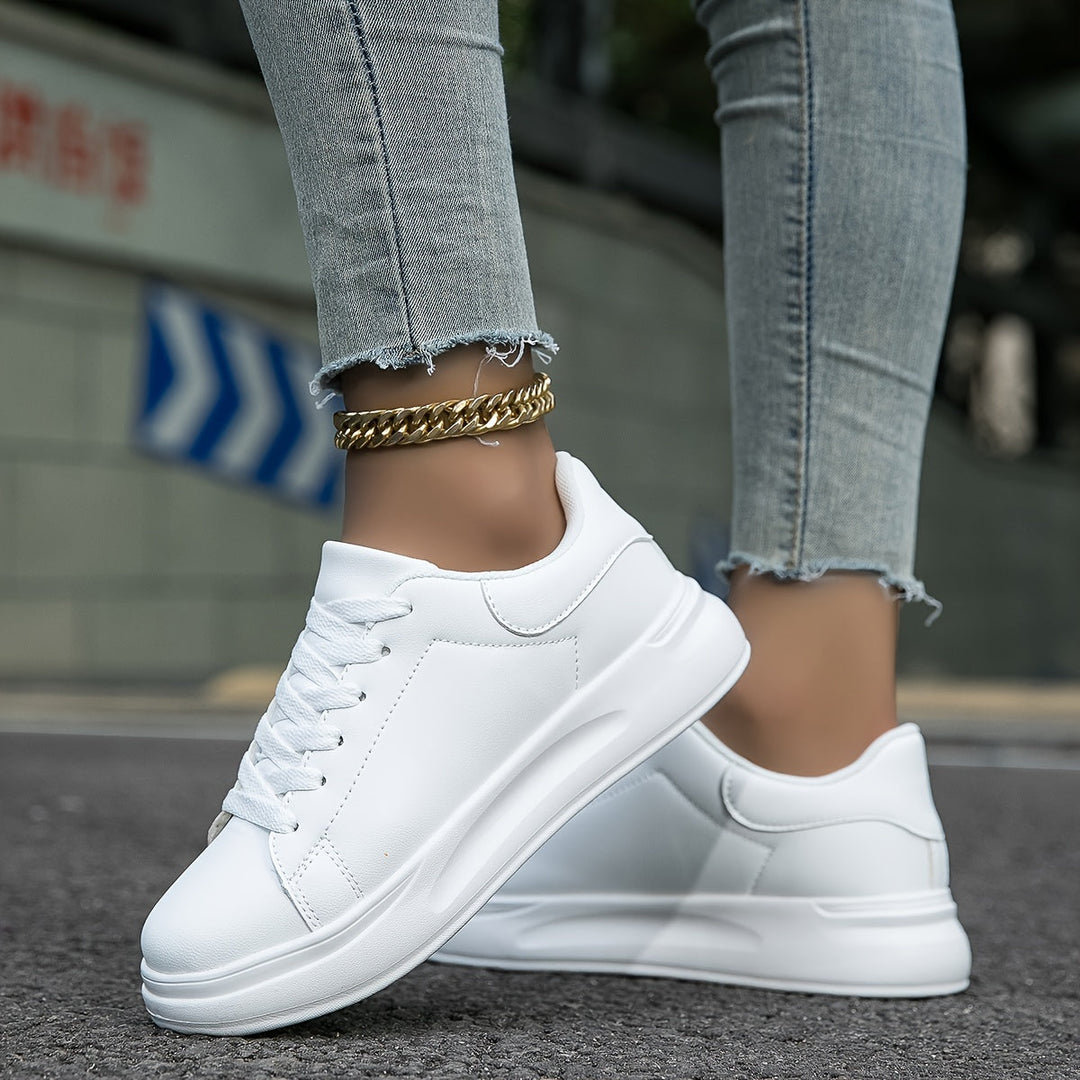 "Women's minimalist white leather sneakers with sleek design and cushioned soles, ideal for casual wear and comfort."