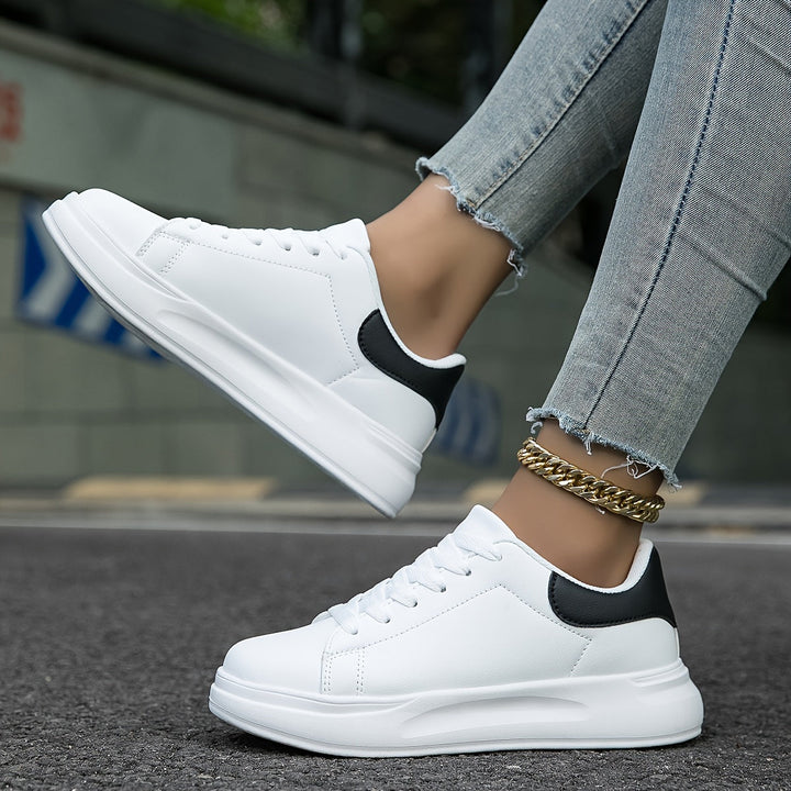 "Women's minimalist white leather sneakers with sleek design and cushioned soles, ideal for casual wear and comfort."
