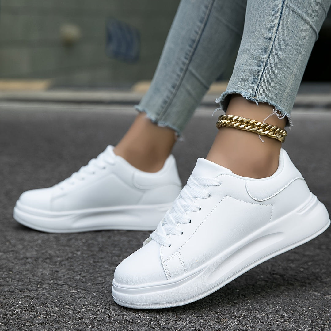 "Women's minimalist white leather sneakers with sleek design and cushioned soles, ideal for casual wear and comfort."