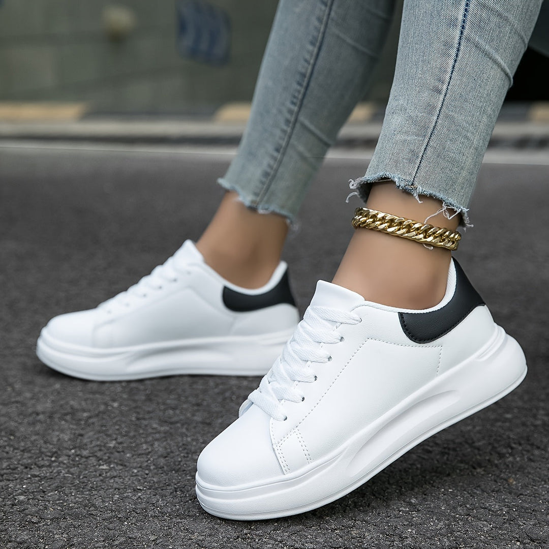 "Women's minimalist white leather sneakers with sleek design and cushioned soles, ideal for casual wear and comfort."