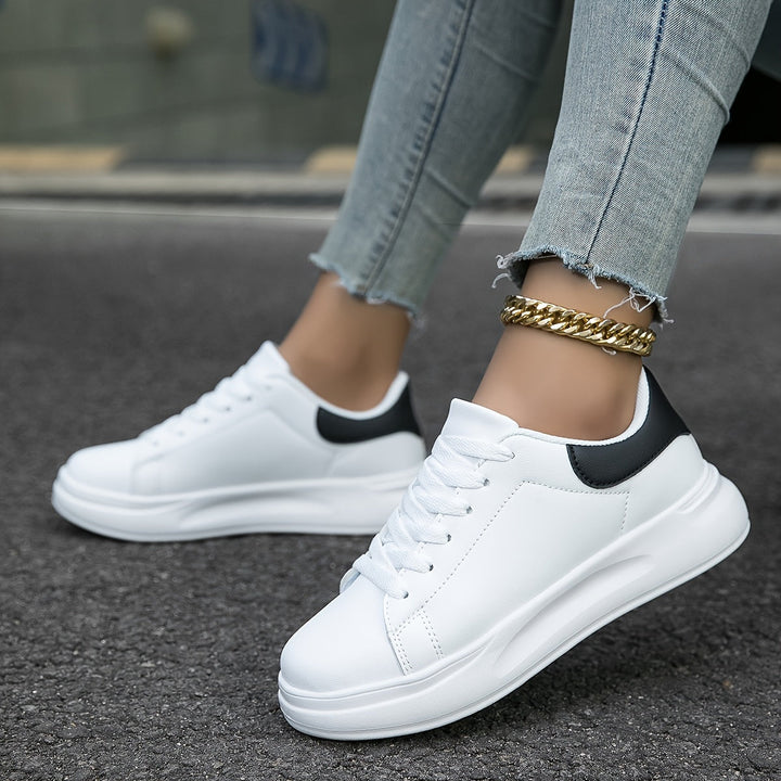 "Women's minimalist white leather sneakers with sleek design and cushioned soles, ideal for casual wear and comfort."