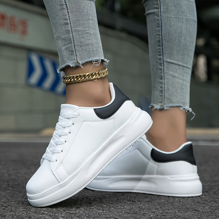 "Women's minimalist white leather sneakers with sleek design and cushioned soles, ideal for casual wear and comfort."