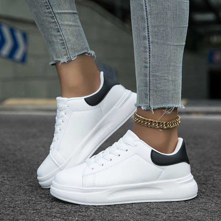 "Women's minimalist white leather sneakers with sleek design and cushioned soles, ideal for casual wear and comfort."