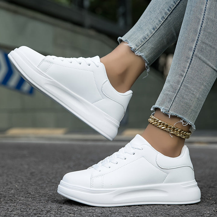 "Women's minimalist white leather sneakers with sleek design and cushioned soles, ideal for casual wear and comfort."