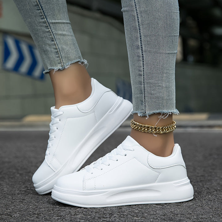 "Women's minimalist white leather sneakers with sleek design and cushioned soles, ideal for casual wear and comfort."