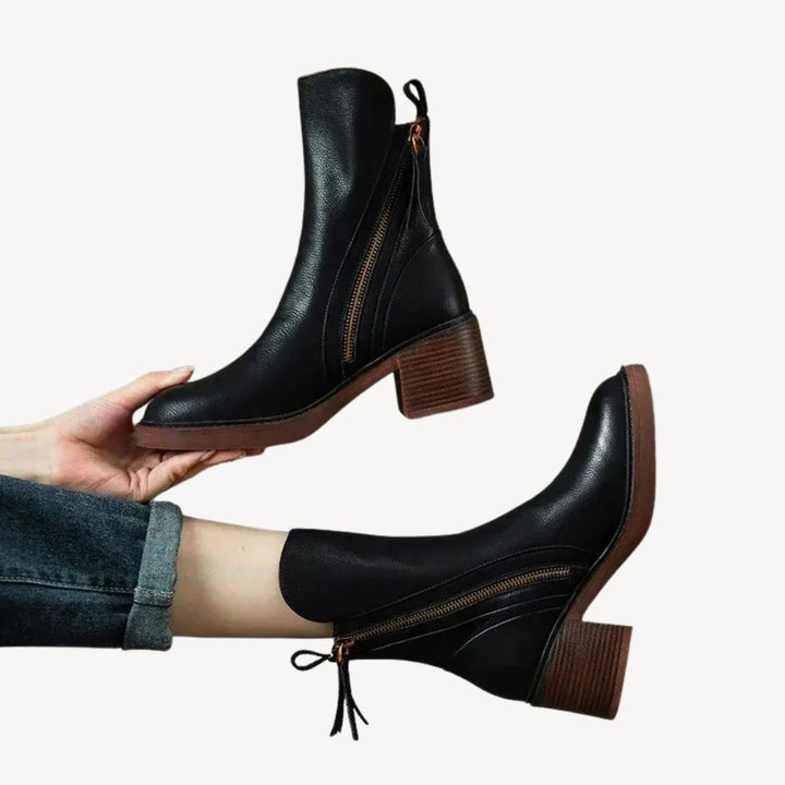 "Women's orthopedic black leather ankle boots with side zipper and moderate heel for comfort and style."