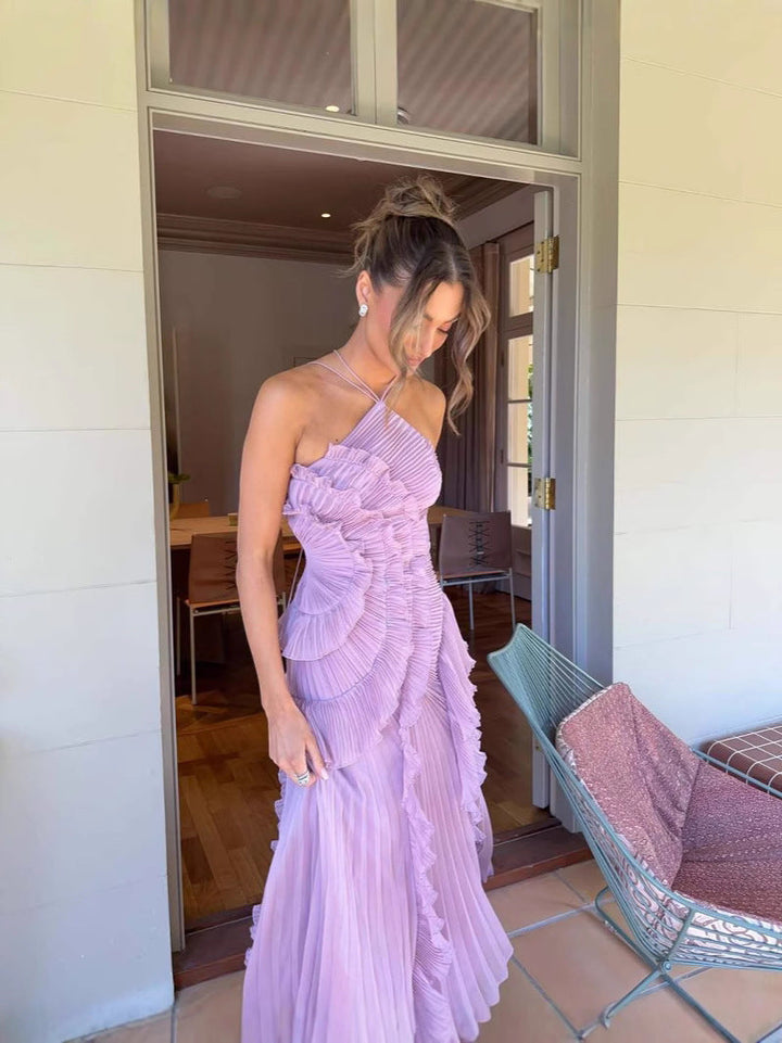 Asymmetric pleated ruffle maxi dress with halter neck, side view; elegant flowy design for special occasions.
