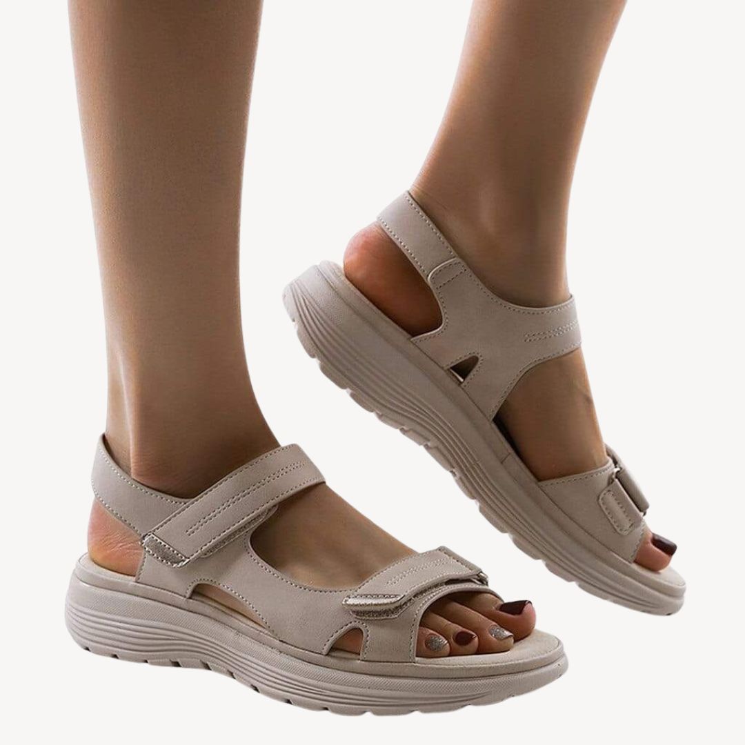 "Beige orthopedic sandals with adjustable straps and arch support, featuring a cushioned shock-absorbing sole."