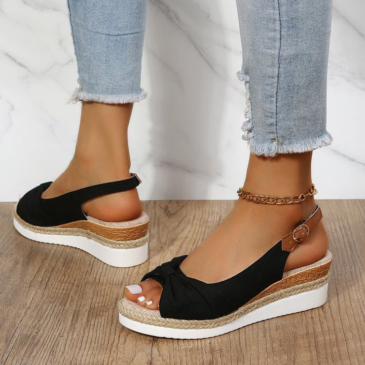 Beige women's wedge sandals with chic knot detail, open toe, slingback strap, and braided jute platform for summer style.