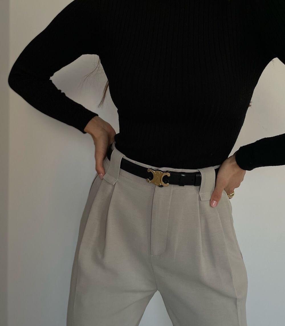 Black leather women's belt with a gold buckle, elegant and versatile for both casual and formal outfits, shown in detail.