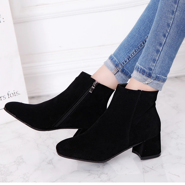 "Black suede women's ankle boots with side zip and low block heel, showcasing a stylish and comfortable design."