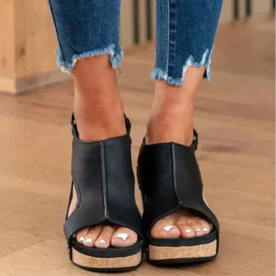 Black women's orthopedic wedge sandals with a cork midsole, faux leather upper, and secure hook-and-loop closure.
