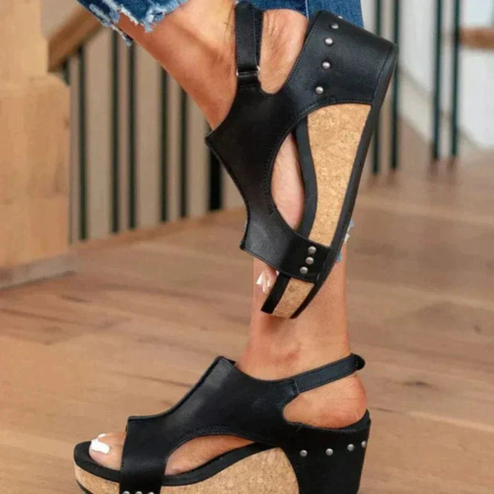 Black women's orthopedic wedge sandals with a cork midsole, faux leather upper, and secure hook-and-loop closure.