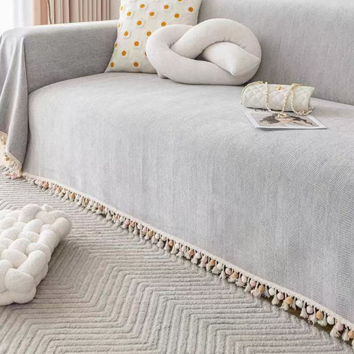 Boho style pet-friendly sofa cover with herringbone pattern and tassels, ideal for stylish protection in living rooms.