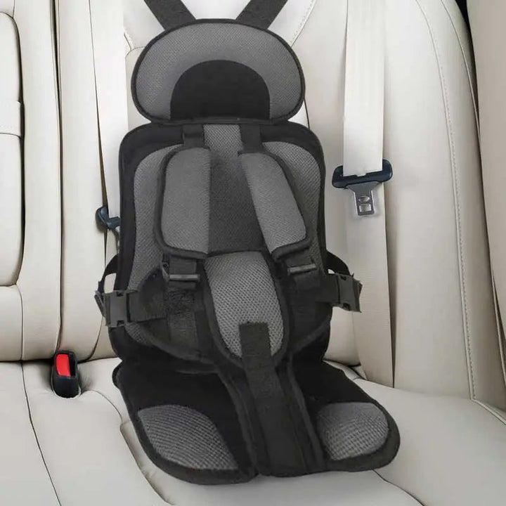 Child car cushion seat in red for ages 0-12, showcasing soft, compact design and secure restraints for safe, comfortable trav