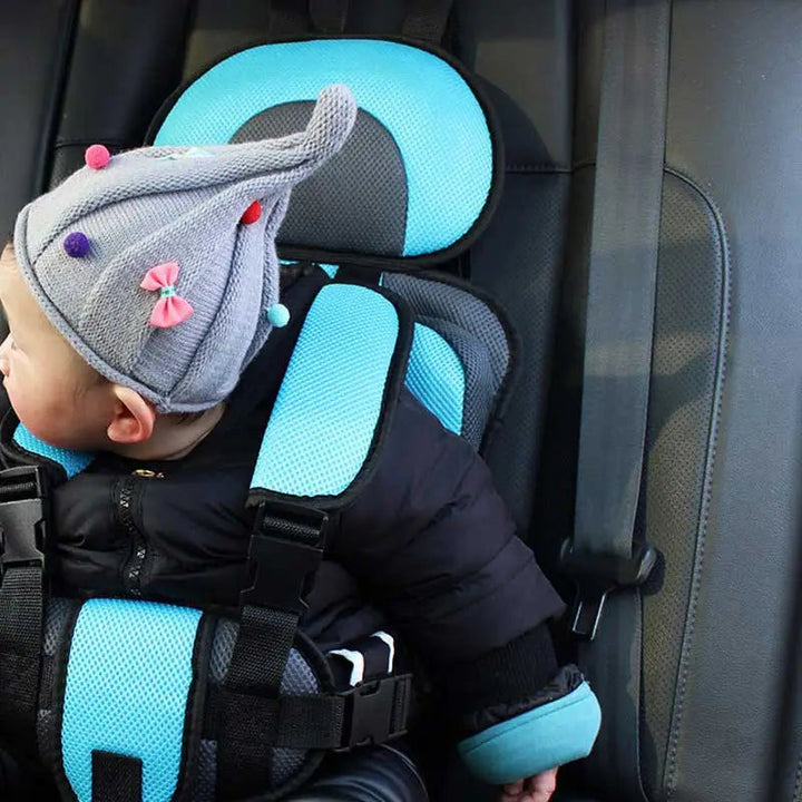 Child car cushion seat in red for ages 0-12, showcasing soft, compact design and secure restraints for safe, comfortable trav